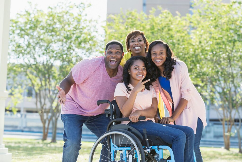 Girl in wheelchair surrounded by happy family